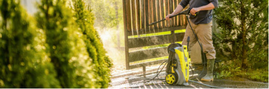 Garden cleaning with electric pressure washer removing weeds