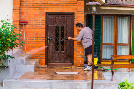 User operating an electric pressure washer on outdoor stairs