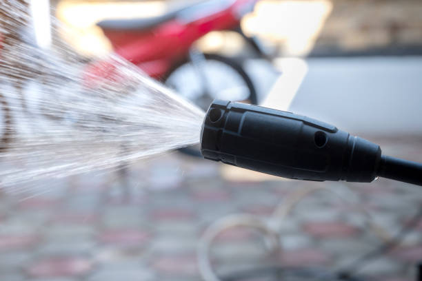 Close-up of an electric pressure washer nozzle spraying water powerfully for cleaning tasks.