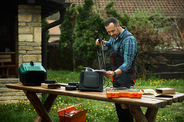 Man assembling equipment outdoors, considering an electric pressure washer for yard cleaning.